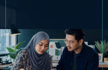 AI Graphic Design Malaysia commercial ebook cover showing two Malaysian creative professionals reviewing a visual brief and layout