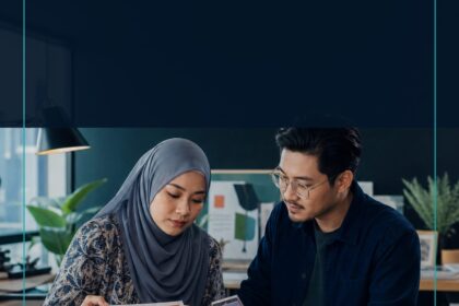 AI Graphic Design Malaysia commercial ebook cover showing two Malaysian creative professionals reviewing a visual brief and layout